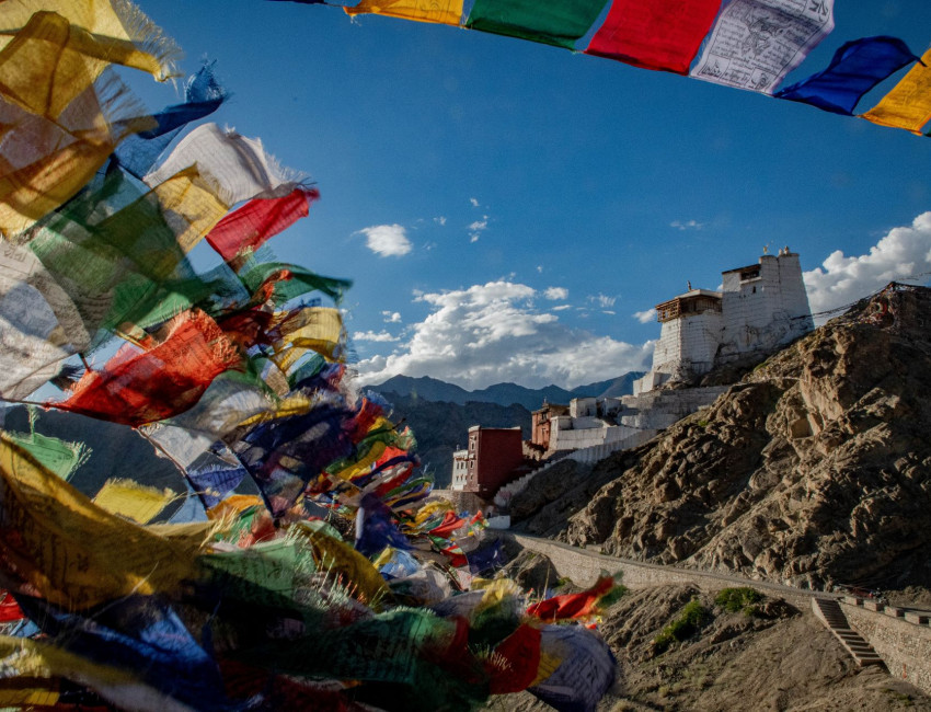 Gompa og buddhistflagg i Himalaya